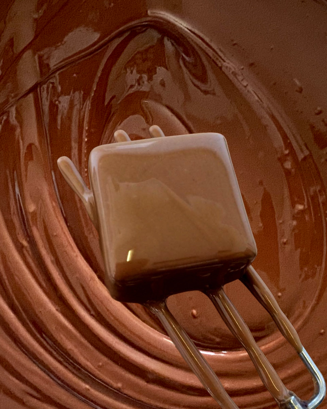 dipping square ganache in chocolate on a fork